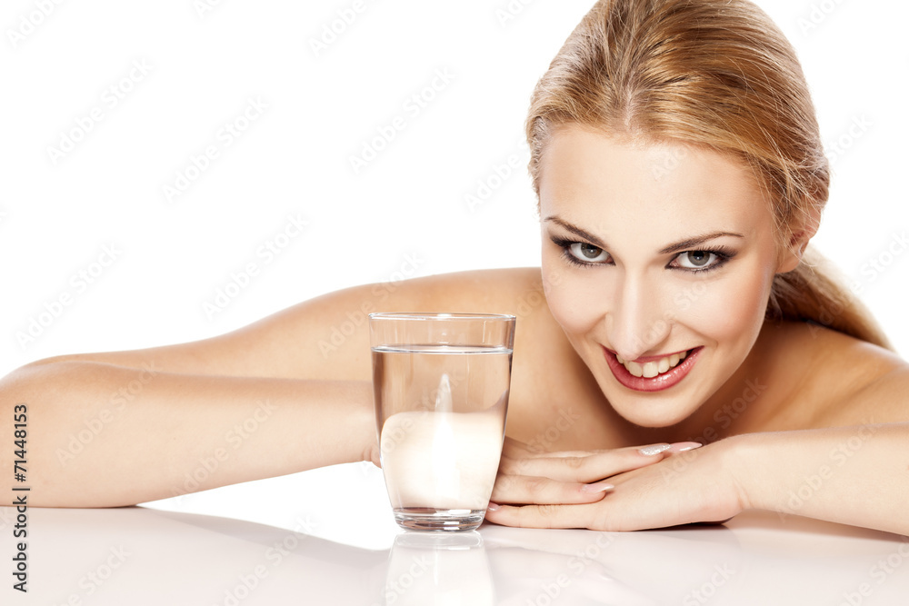 beautiful blonde with makeup lie by glass with water beautiful blonde with makeup lie by glass with water
