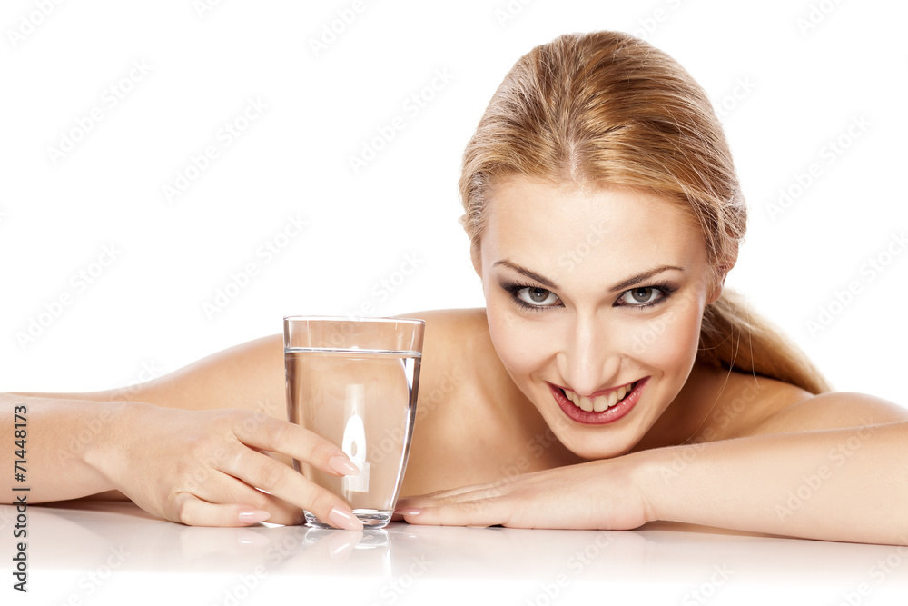 beautiful blonde with makeup lie by glass with water beautiful blonde with makeup lie by glass with water