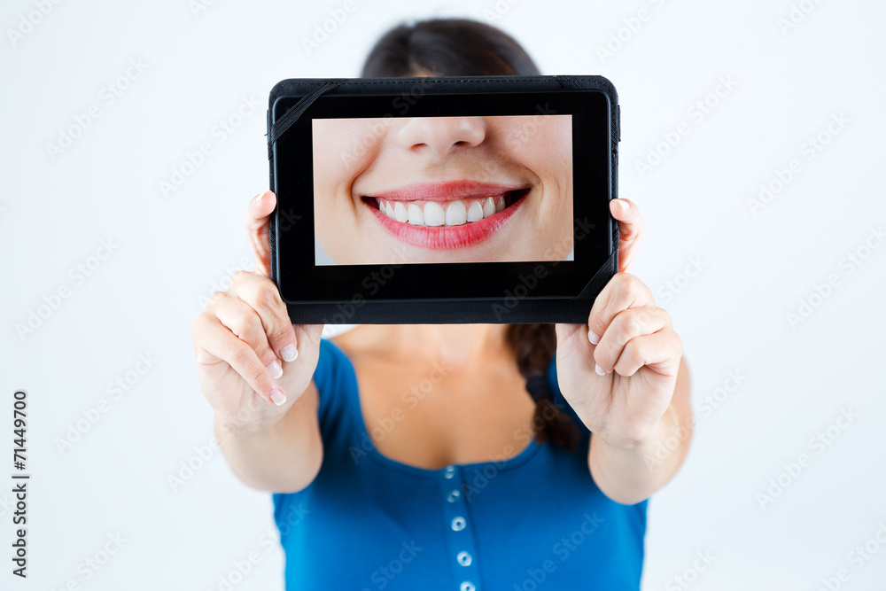 Beautiful girl holding a picture of a mouth smiling.