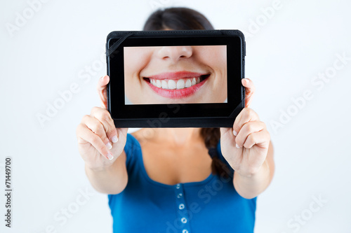 Beautiful girl holding a picture of a mouth smiling. photo