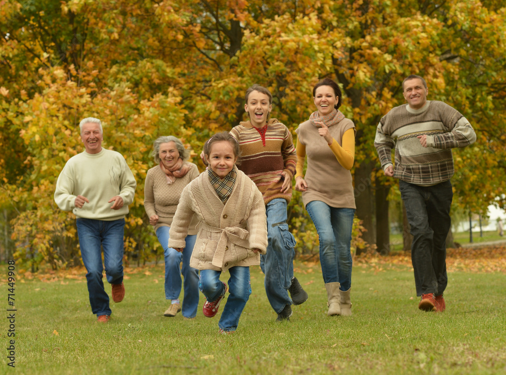 family relaxing in autumn forest