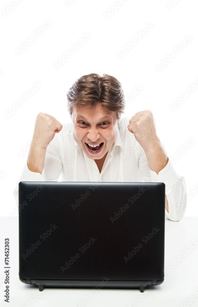 Happy young man looking at laptop and gesturing Happy young man looking at laptop and gesturing
