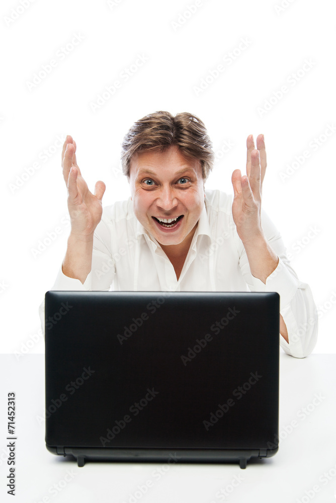 Happy young man looking at laptop and gesturing Happy young man looking at laptop and gesturing