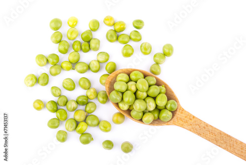 Green peas in a wooden spoon on a white background.