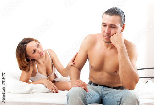 Middle-aged man has problem, a woman comforting him in bed at be
