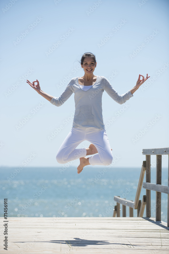 young woman full of energy jumping on a pontoon in front of the young woman full of energy jumping on a pontoon in front of the