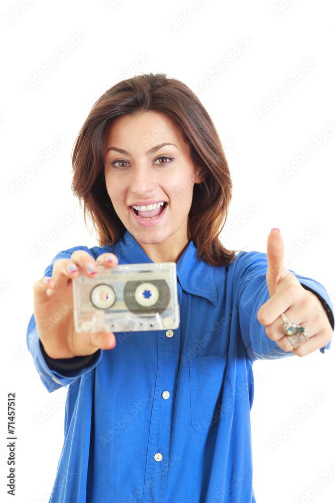 Pretty woman holding audio cassette showing thumbs up smiling Pretty woman holding audio cassette showing thumbs up smiling