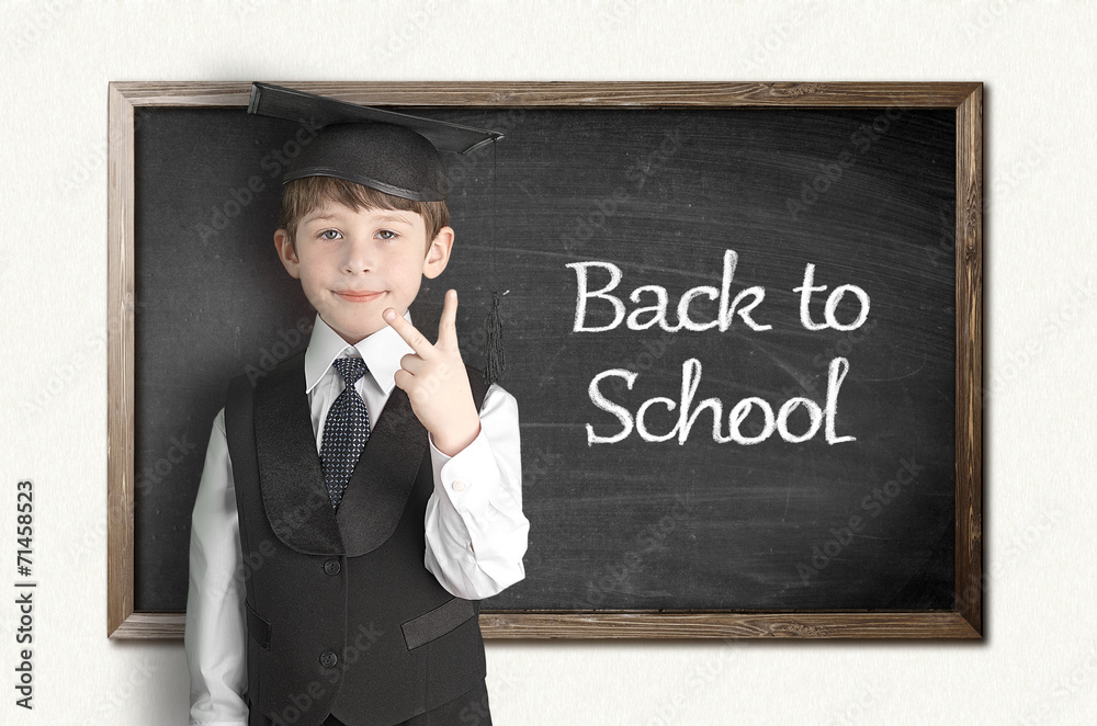 Cheerful little boy on blackboard. Looking at camera Cheerful little boy on blackboard. Looking at camera