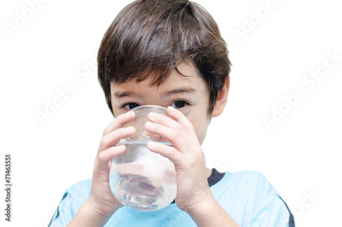 little boy drinks water from a glass