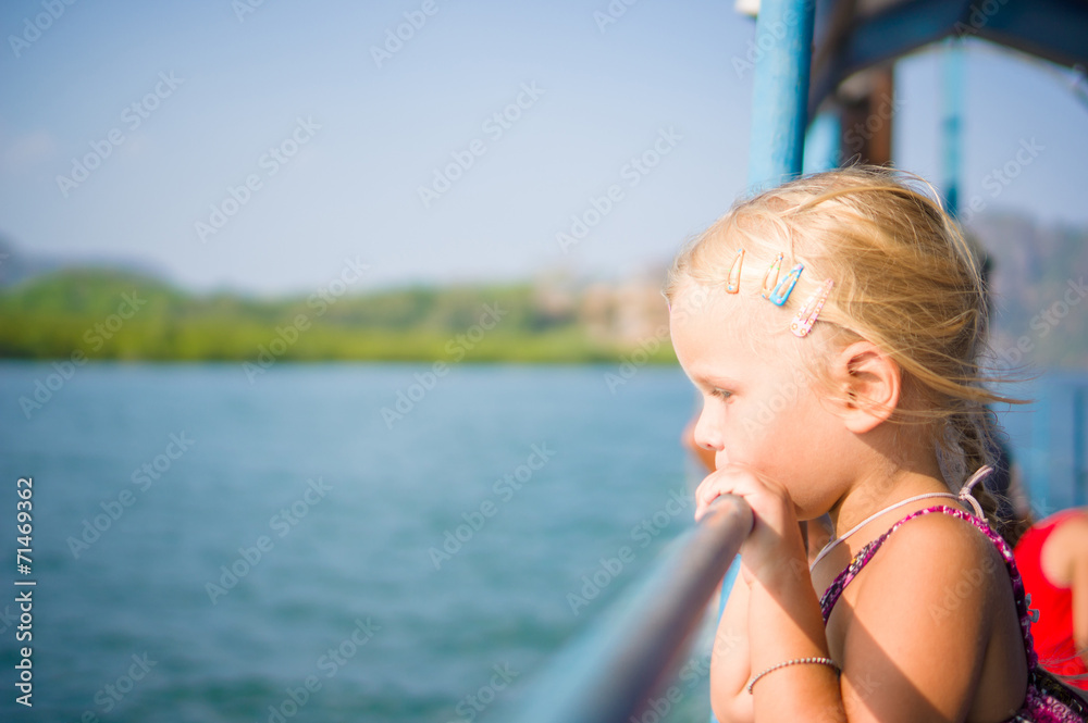 Adorable girl see out to water on upper deck of ferry boat betwe