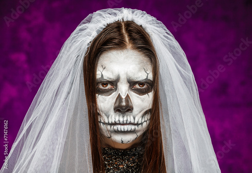 Young woman a bride in a veil on the day of the dead mask skull