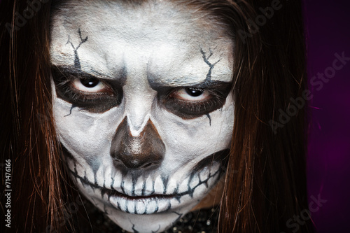 Young woman in day of the dead mask skull face art.