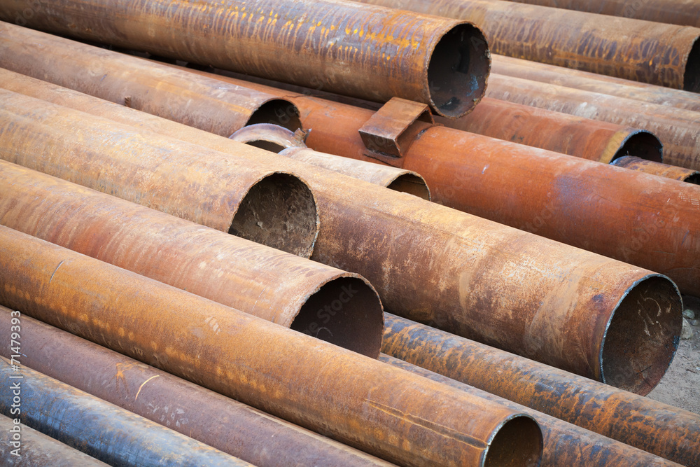 Pile of rusted industrial steel pipes lay on the ground Pile of rusted industrial steel pipes lay on the ground