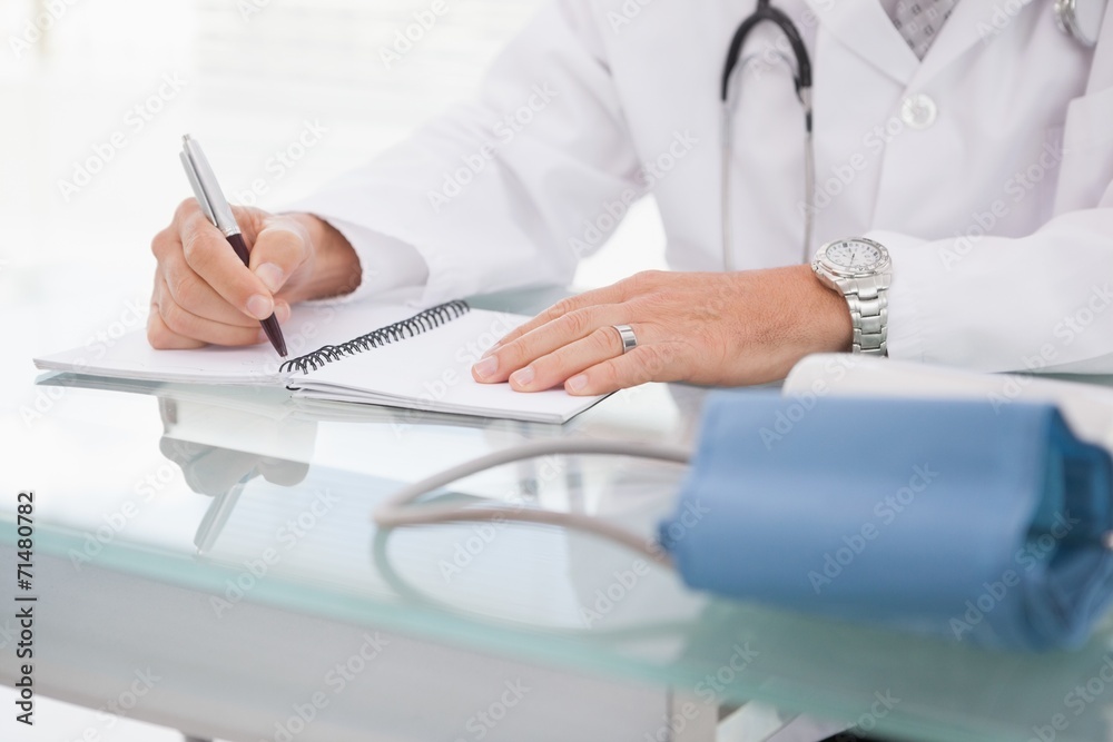 Doctor writing on a notepad