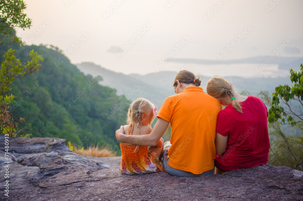 Family seat near cliff on the top of tropical island mountain on