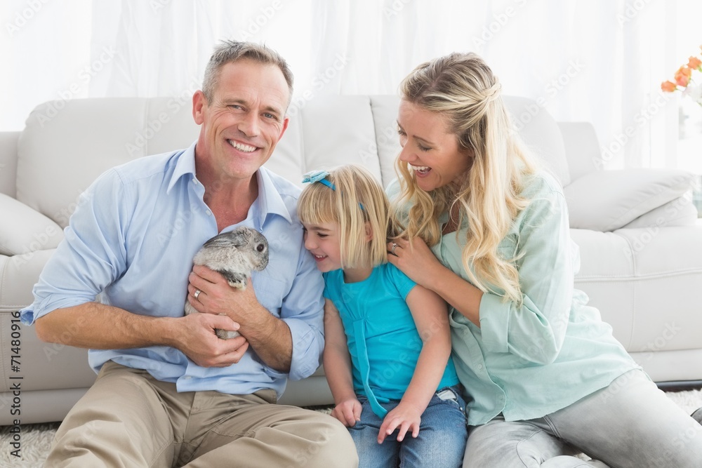 Smiling parents and daughter sitting with rabbit together Smiling parents and daughter sitting with rabbit together