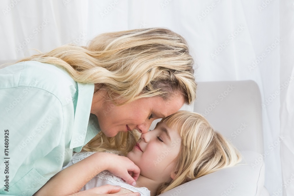 Mother and daughter rubbing noses on sofa Mother and daughter rubbing noses on sofa