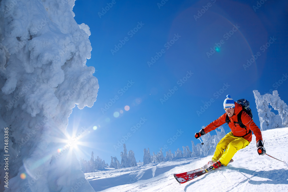 Skier against blue sky in high mountains - obrazy, fototapety, plakaty 