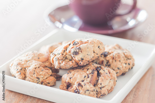 Closeup mixed nut cookies with violet coffee cup