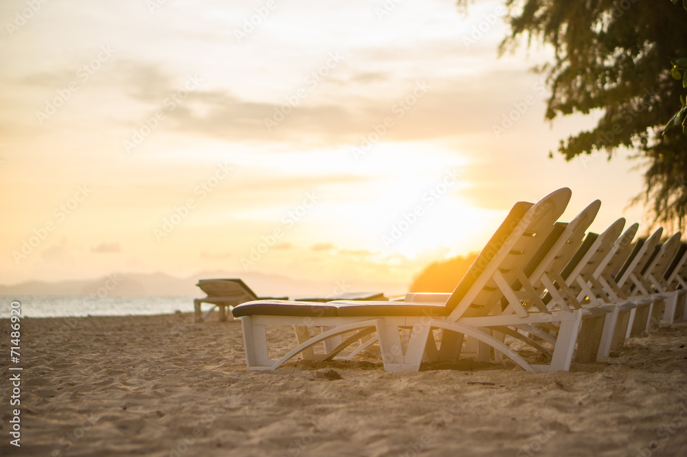 Rows of beach chairs at sunset near tropical ocean resort Rows of beach chairs at sunset near tropical ocean resort