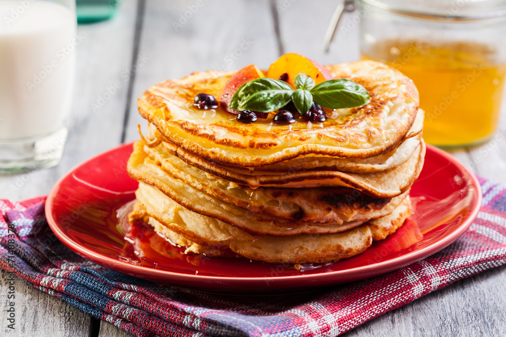 Pancakes with honey, fruit and glass of milk Pancakes with honey, fruit and glass of milk