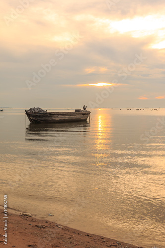 old boat in front of sunset background near beach © sarayuth3390