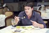 young man having dinner in a restaurant