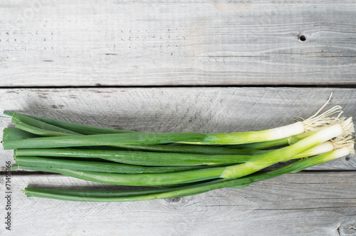 Bunch of spring onions against wooden background