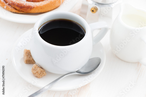cup of black coffee and sweet bun