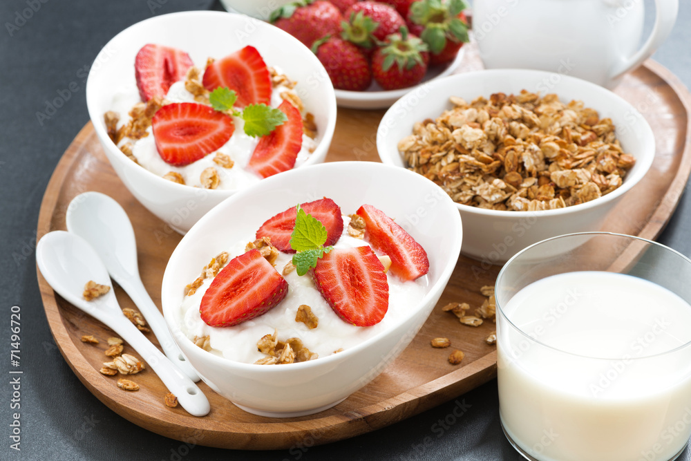 healthy breakfast - yogurt, fresh strawberries, granola and milk