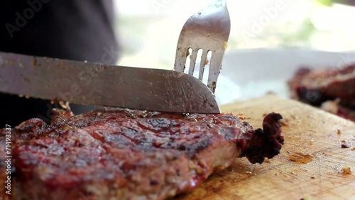 Fire Grilled Steak is Cut into Pieces on a Wooden Board