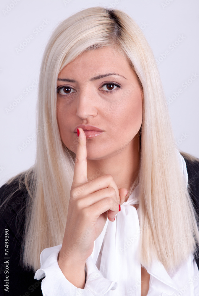 Young woman with finger on lips over white background Young woman with finger on lips over white background