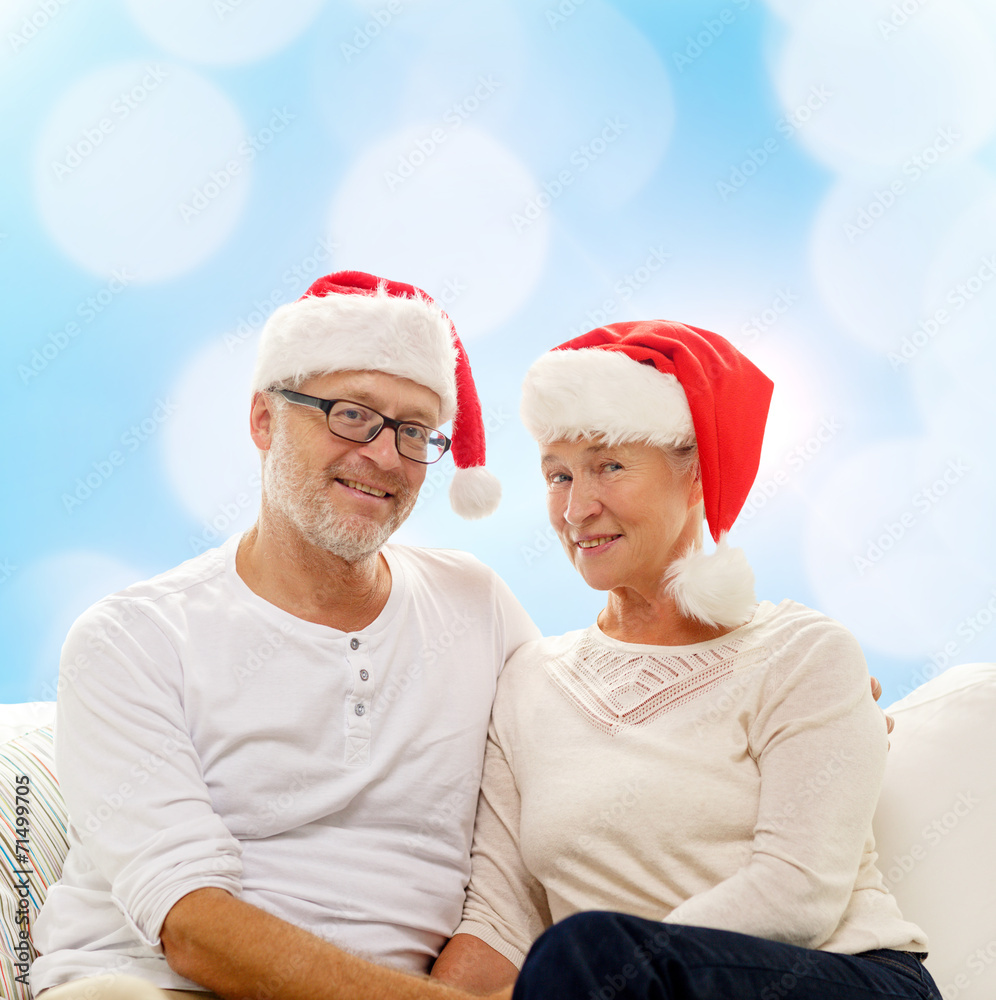 happy senior couple in santa helper hats