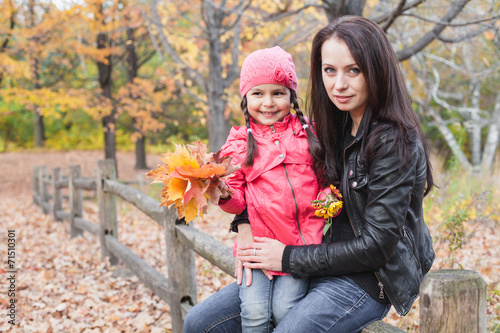 Little pretty girl with her mother in an autumn park