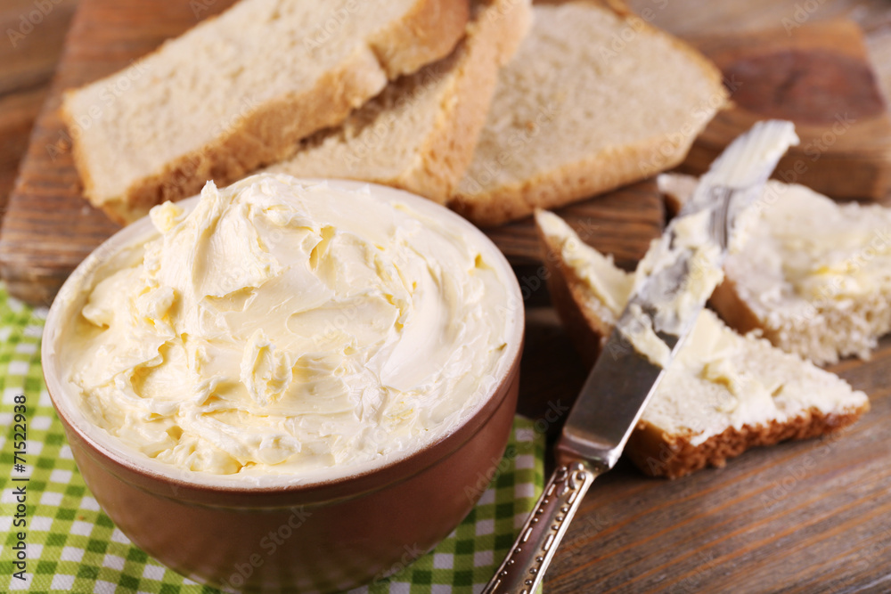 Fresh homemade butter in bowl and sliced bread,