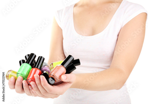 Colorful nail polishes in hands, close-up