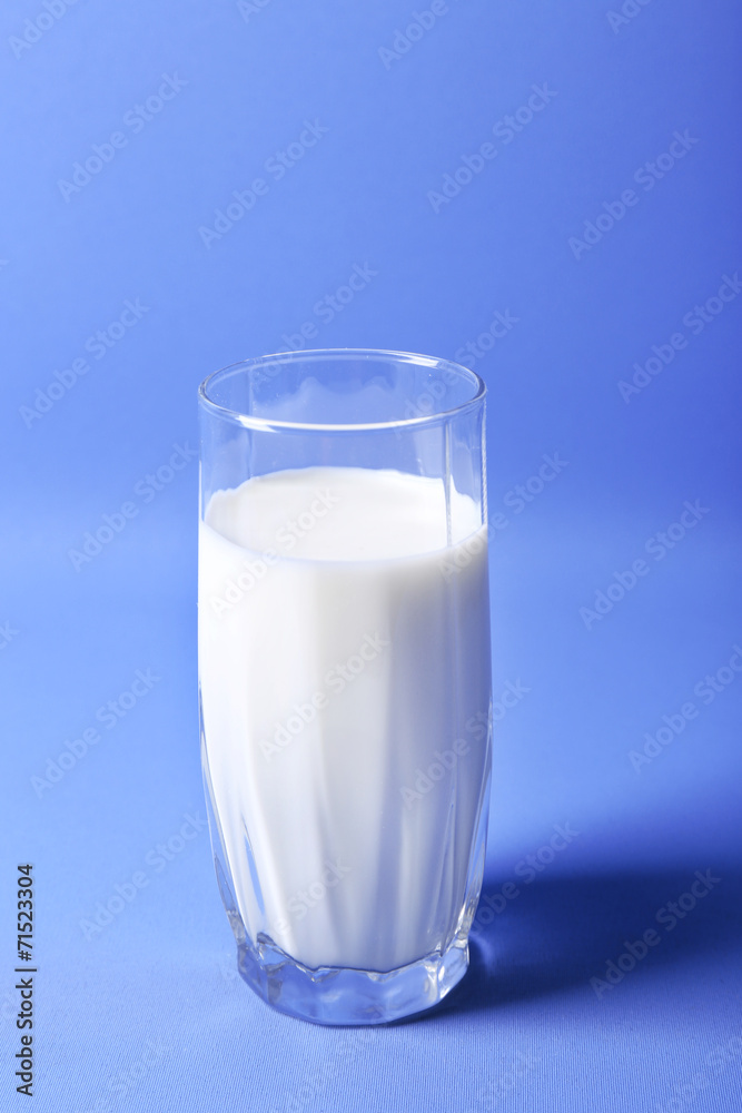 Milk in glass on blue background Milk in glass on blue background