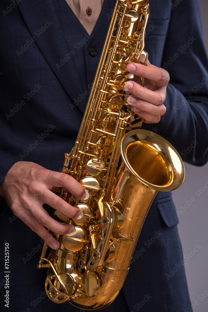 Obraz premium Close-up picture of a trumpet in hands of a jazz man in a suit i