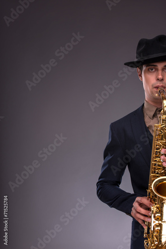 Photography Portrait of a young handsome Caucasian jazz man in a suit with a