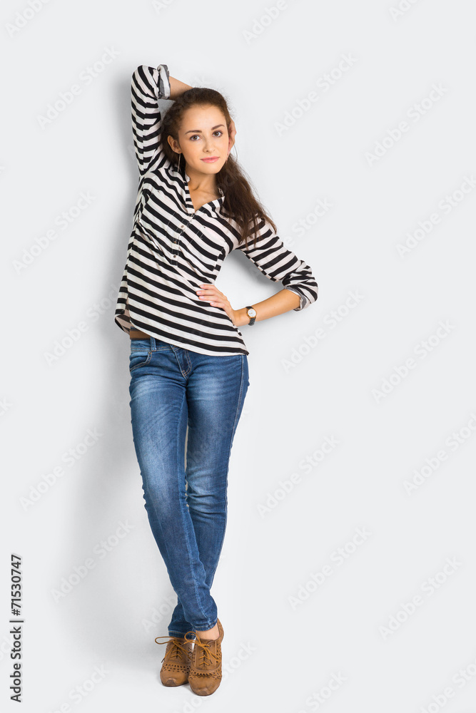 A shot of attractive young casual woman standing at the wall A shot of attractive young casual woman standing at the wall