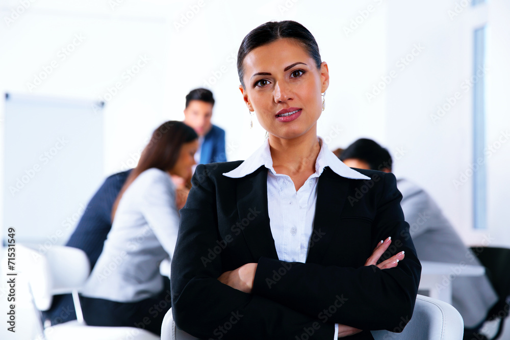 Businesswoman with arms folded standing in front of a metting Businesswoman with arms folded standing in front of a metting