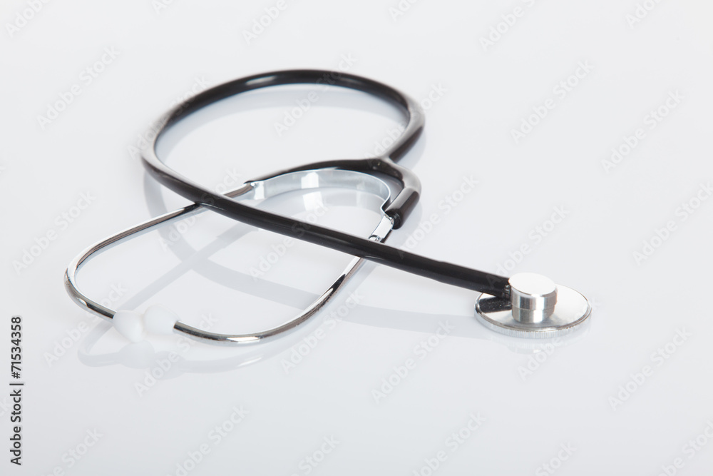 Black Stethoscope on white glossy table Black Stethoscope on white glossy table