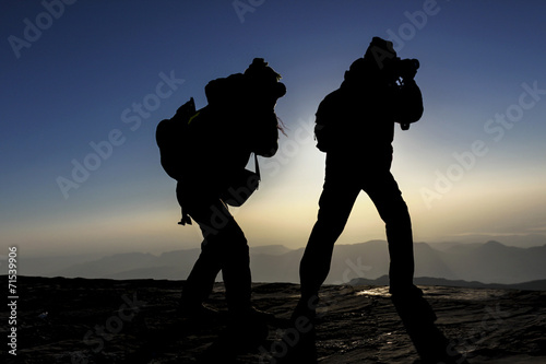 two silhoutte photographers in the mountain