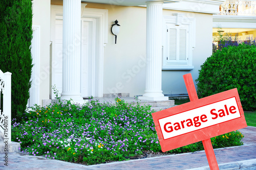 Garage sale sign in front of house