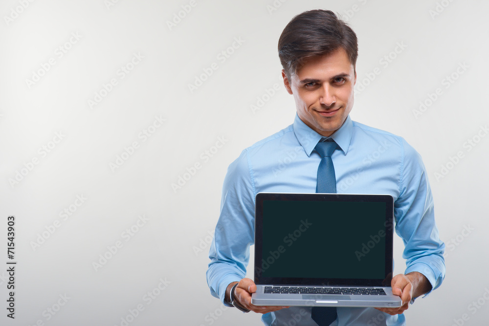 Business man holding a laptop against a white background Business man holding a laptop against a white background