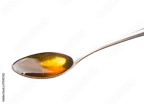 A spoon of honey over white background