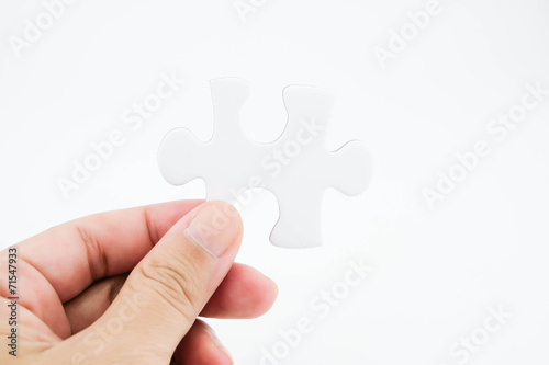 Jigsaw puzzle in hand isolated on white background for business