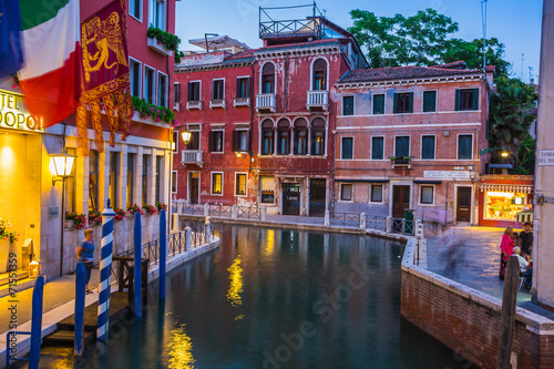 Narrow canal among old colorful brick houses in Venice