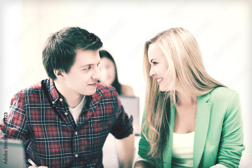 smiling students looking at each other at school smiling students looking at each other at school