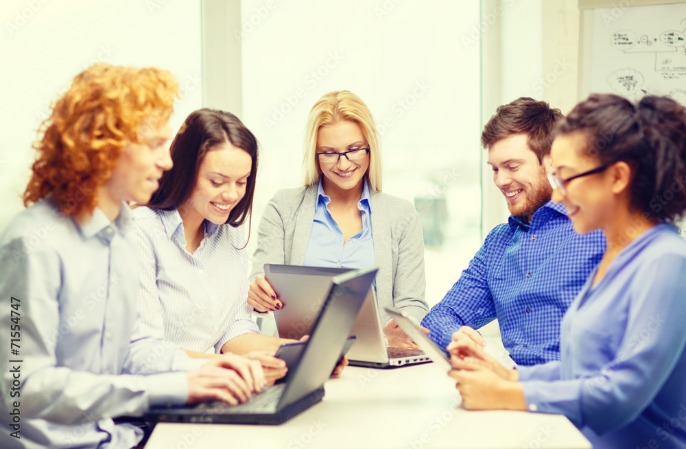 smiling team with laptop and table pc computers